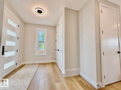 Entryway featuring light wood-finish flooring, white trim, and a window providing natural light - 