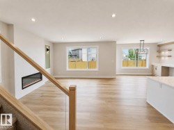 Open-concept living space featuring wood-finish flooring, recessed lighting, and large windows - 