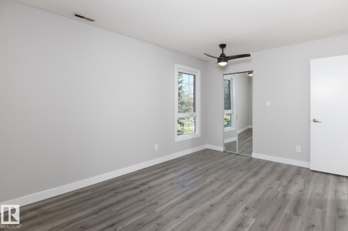 Room featuring wood-finish flooring, light gray wall paint, and white baseboards - 5816 172 Street, Edmonton, AB - Indoor Photo Showing Other Room