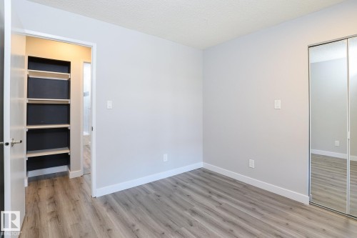 Interior space featuring wood-finish flooring, light grey painted walls, and white baseboards - 5816 172 Street, Edmonton, AB - Indoor Photo Showing Other Room