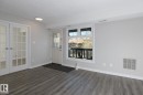 Spacious room featuring wood-finish flooring, light grey wall paint, and white trim - 5816 172 Street, Edmonton, AB  - Indoor Photo Showing Other Room 