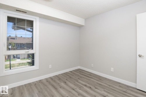 Room with light gray walls, wood-finish flooring, and white trim - 5816 172 Street, Edmonton, AB - Indoor Photo Showing Other Room