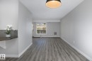 Spacious room featuring wood-finish flooring, light grey walls, and white trim - 5816 172 Street, Edmonton, AB  - Indoor Photo Showing Other Room 