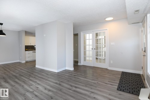 Open concept living area featuring wood-finish flooring, white baseboards, and a neutral wall color - 5816 172 Street, Edmonton, AB - Indoor