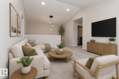 Vaulted ceiling living area featuring recessed lighting, a modern pendant light fixture, light-toned carpet flooring, and a half-wall overlooking a lower level - 2616 158 Street, Edmonton, AB - Indoor