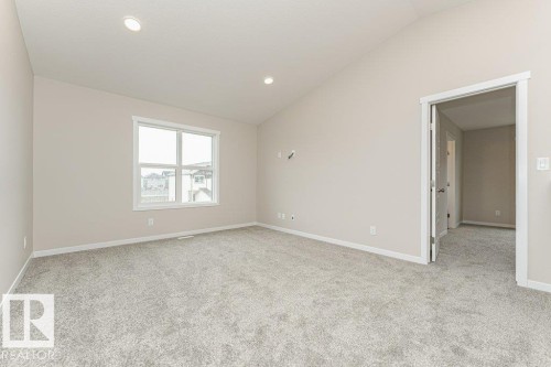 Spacious room featuring vaulted ceilings, light gray carpet, recessed lighting, and a large window with white trim - 2616 158 Street, Edmonton, AB - Indoor Photo Showing Other Room