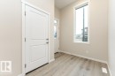Entryway featuring durable wood-finish flooring, neutral wall tones, white trim, and a tall window - 2616 158 Street, Edmonton, AB  - Indoor Photo Showing Other Room 