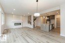 Spacious living area featuring wood-finish flooring, a modern electric fireplace with a mantel, and recessed lighting - 2616 158 Street, Edmonton, AB  - Indoor With Fireplace 