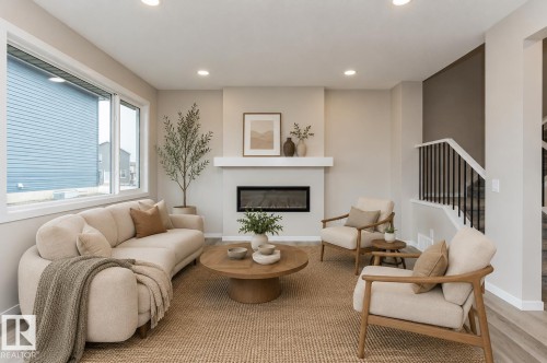 Living area featuring a sleek linear fireplace with a white mantel, recessed lighting, and large picture windows - 2616 158 Street, Edmonton, AB - Indoor Photo Showing Living Room With Fireplace