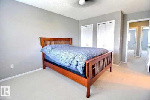 Carpeted bedroom with neutral gray walls, a popcorn ceiling, and a ceiling fan - 170 Keystone Crescent, Leduc, AB - Indoor Photo Showing Bedroom