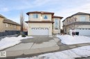 The property features a two-car garage, a paved driveway, and an arched entry window - 4831 154 Avenue, Edmonton, AB  - Outdoor With Facade 