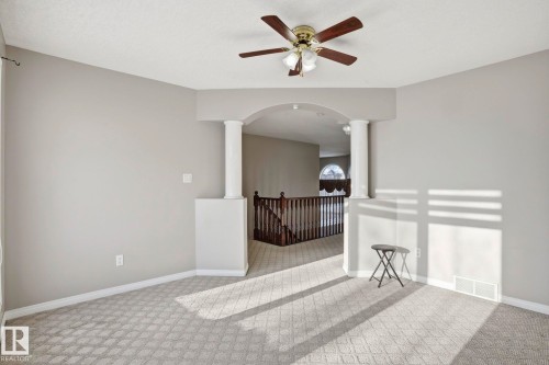 Living area featuring light grey walls, patterned carpet, and a ceiling fan with light fixture - 4831 154 Avenue, Edmonton, AB - Indoor