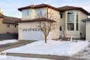 The property features a two-car garage with a paved driveway, stucco exterior, and a prominent arched window design - 4831 154 Avenue, Edmonton, AB  - Outdoor 