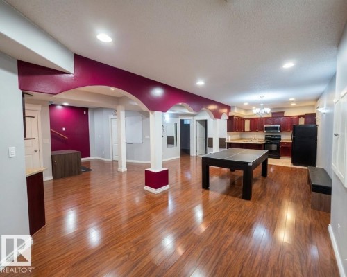 Spacious open-concept area featuring polished wood flooring and recessed lighting - 4831 154 Avenue, Edmonton, AB - Indoor Photo Showing Other Room