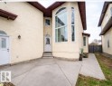 The property features a stucco exterior, a prominent arched window, and a white front door with an arched transom - 4831 154 Avenue, Edmonton, AB  - Outdoor 