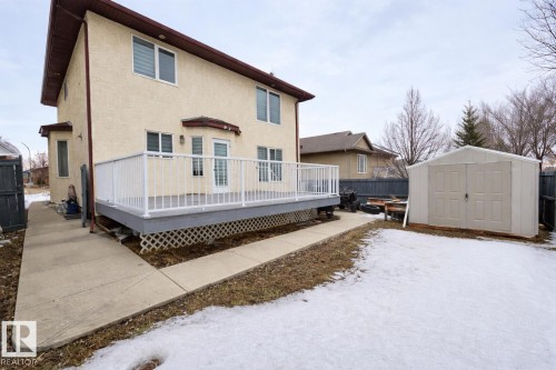 The property features a private deck with white railings, a concrete pathway, and a detached shed in the yard - 4831 154 Avenue, Edmonton, AB - Outdoor With Deck Patio Veranda With Exterior