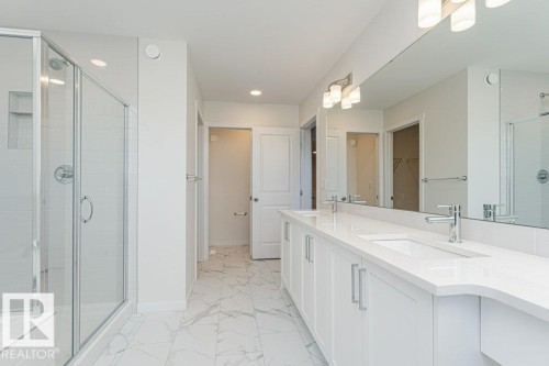 Spacious bathroom featuring a double vanity with stone countertops, undermount sinks, and chrome fixtures - 6271 180 Avenue, Edmonton, AB - Indoor Photo Showing Bathroom