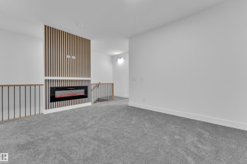 Feature wall with vertical wood slat detailing and integrated linear electric fireplace - 3116 8 Avenue, Edmonton, AB - Indoor Photo Showing Other Room