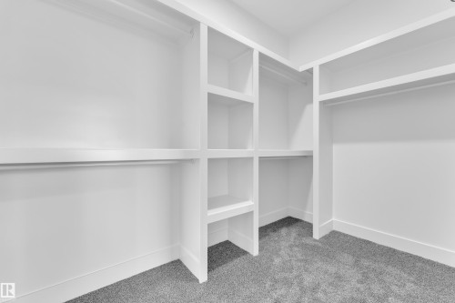 Custom closet system with white shelving and hanging rods - 3116 8 Avenue, Edmonton, AB - Indoor With Storage