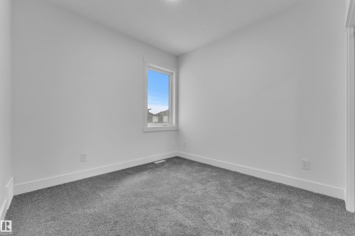 Bedroom featuring light gray carpet flooring, white walls, and a window with white trim - 3116 8 Avenue, Edmonton, AB - Indoor Photo Showing Other Room