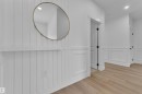 White wainscoting and board and batten wall details, light wood-finish flooring, recessed lighting, and black hardware on interior doors - 3116 8 Avenue, Edmonton, AB  - Indoor Photo Showing Other Room 