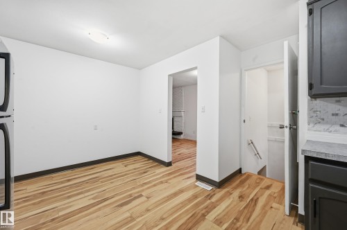Wood-finish flooring throughout, white walls, and a recessed ceiling light create a bright interior - 13903 87 Street, Edmonton, AB - Indoor Photo Showing Other Room