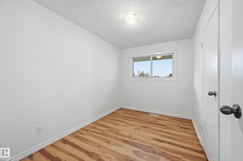 Neutral white walls with wood-finish flooring - 13903 87 Street, Edmonton, AB - Indoor Photo Showing Other Room