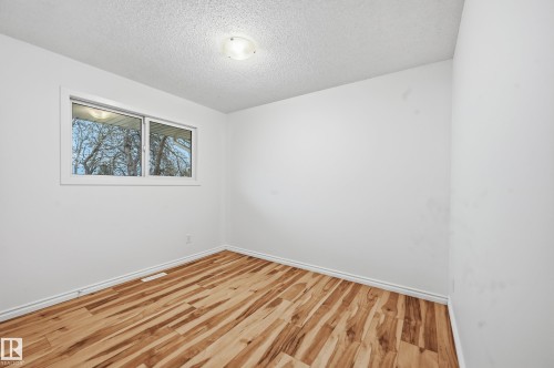 Room featuring light wood-finish flooring, white baseboards, a white window frame, and a flush mount ceiling light fixture - 13903 87 Street, Edmonton, AB - Indoor Photo Showing Other Room
