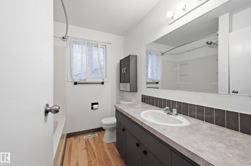 Bathroom featuring a single vanity with a countertop, integrated sink, and dark cabinetry - 13903 87 Street, Edmonton, AB - Indoor Photo Showing Bathroom