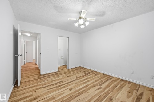 Spacious room featuring wood-finish flooring, white walls, and a ceiling fan with integrated lighting - 13903 87 Street, Edmonton, AB - Indoor Photo Showing Other Room