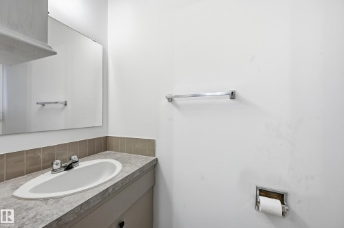 Bathroom vanity featuring an oval undermount sink, laminate countertop, chrome faucet, and tiled backsplash - 13903 87 Street, Edmonton, AB - Indoor Photo Showing Bathroom