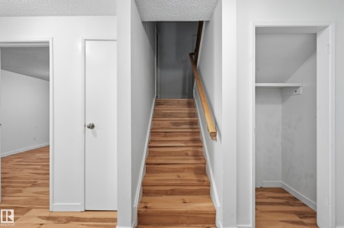 Staircase with wood-finish treads and a natural wood handrail - 13903 87 Street, Edmonton, AB - Indoor Photo Showing Other Room