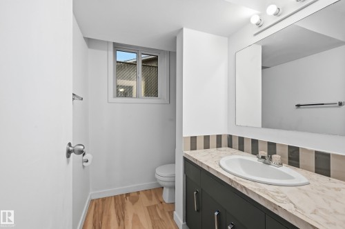 Bathroom featuring a vanity with a light-toned countertop, integrated sink, and dark cabinetry with silver-toned hardware - 13903 87 Street, Edmonton, AB - Indoor Photo Showing Bathroom