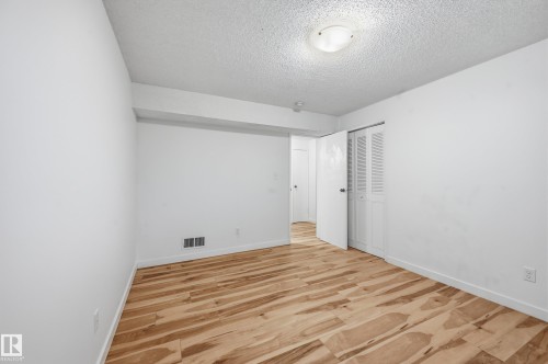 Room featuring wood-finish flooring, white walls, and a textured ceiling - 13903 87 Street, Edmonton, AB - Indoor Photo Showing Other Room