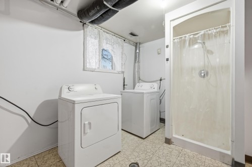 Laundry area with a stand-up shower, window, and patterned tile flooring - 13903 87 Street, Edmonton, AB - Indoor Photo Showing Laundry Room