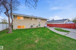 Expansive green lawn with a detached building in the background - 