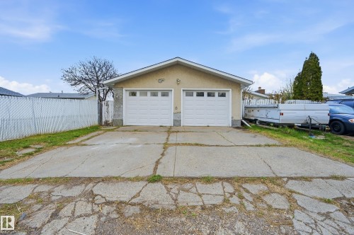 Detached two-car garage with two white overhead doors and concrete driveway - 13903 87 Street, Edmonton, AB - Outdoor