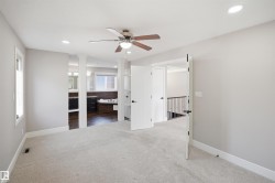 Spacious carpeted room featuring a ceiling fan, recessed lighting, and white trim - 