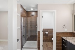 Full bathroom featuring a glass-enclosed shower with wood-look tile surround and a rain showerhead - 