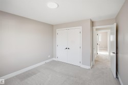 Neutral-toned room featuring light gray carpeting and white trim - 