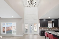 Soaring vaulted ceilings with a decorative chandelier highlight this open-concept space - 