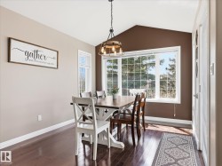 Dining space featuring a vaulted ceiling and dark wood-finish flooring - 