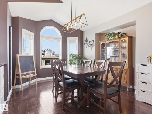 Dining area featuring rich wood-finish flooring, a vaulted ceiling, and an arched window - 1340 Oakland Crescent, Devon, AB - Indoor Photo Showing Dining Room