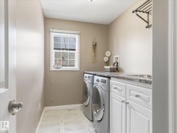 Dedicated laundry area featuring a window, built-in cabinetry, a utility sink, and a countertop - 