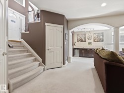Carpeted staircase with white balustrade leading to a main entrance door with a transom window - 