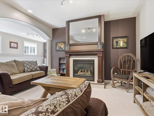 Living area featuring a fireplace with a wood mantle, a large mirror, and recessed lighting - 1340 Oakland Crescent, Devon, AB - Indoor Photo Showing Living Room With Fireplace