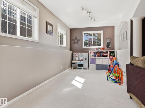 Spacious room featuring light-toned carpeting and multiple windows - 1340 Oakland Crescent, Devon, AB - Indoor Photo Showing Other Room