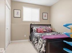 Neutral-toned room featuring a window with horizontal blinds, soft carpet flooring, and white trim throughout - 
