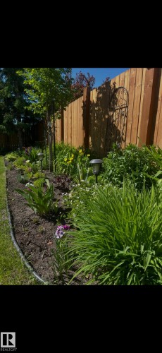 Manicured garden bed featuring diverse plantings, perimeter edging, and integrated path lighting - 1340 Oakland Crescent, Devon, AB - Outdoor