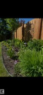 Manicured garden bed featuring diverse plantings, perimeter edging, and integrated path lighting - 